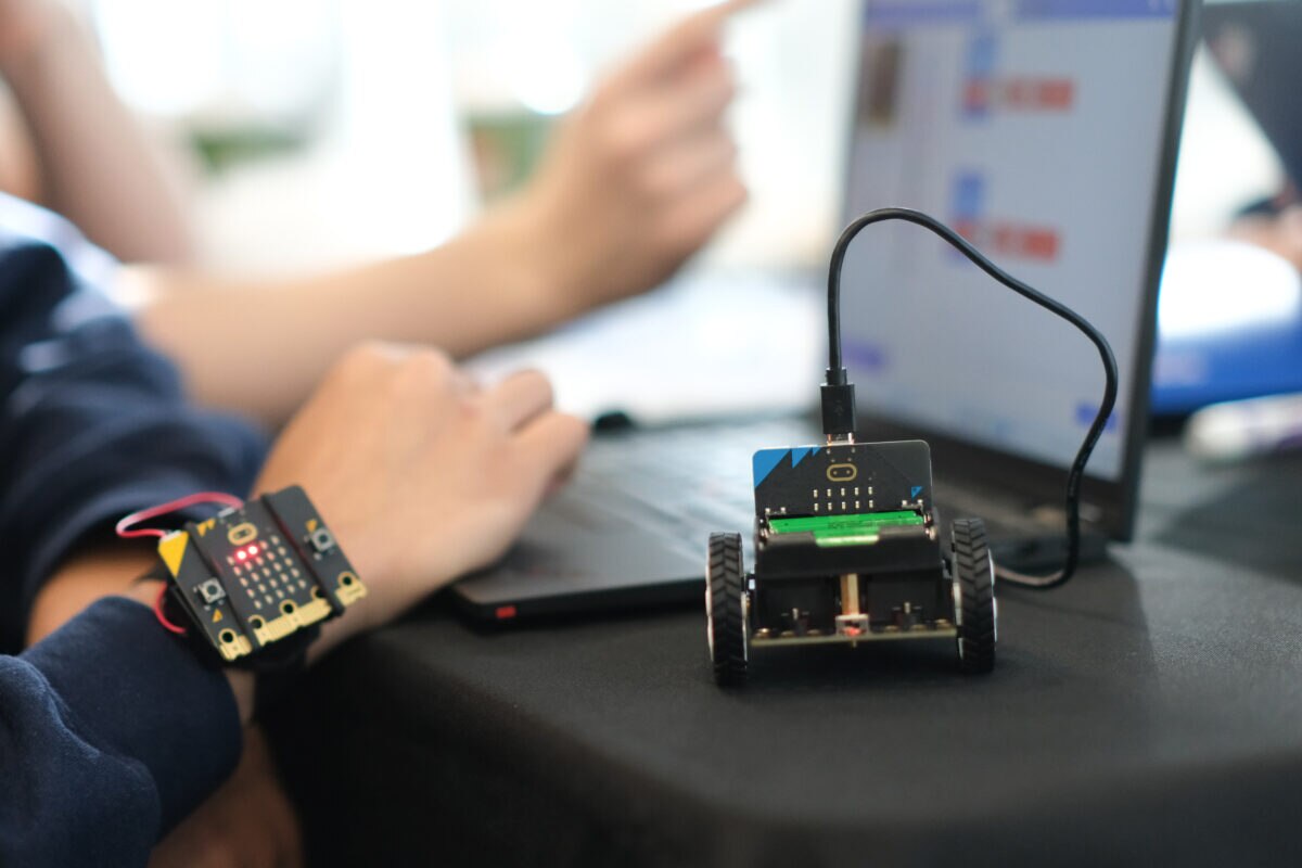 BBC micro:bit-powered robotic vehicle beside a laptop during the Drive the Future 2026 engineering activity.