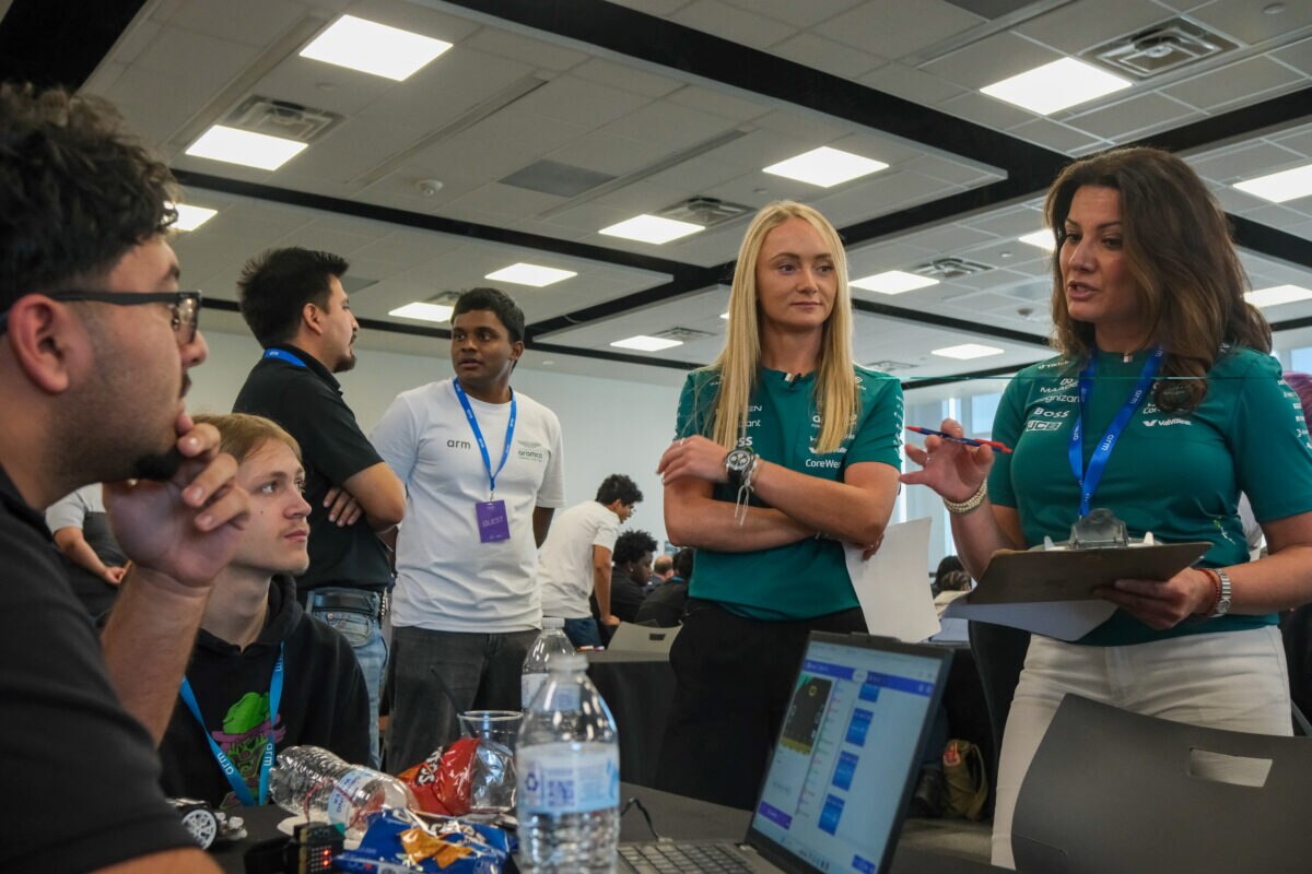 Jessica Hawkins and Anahita Crawford speaking with students working on laptops during Arm's Drive the Future 2026 STEM event.